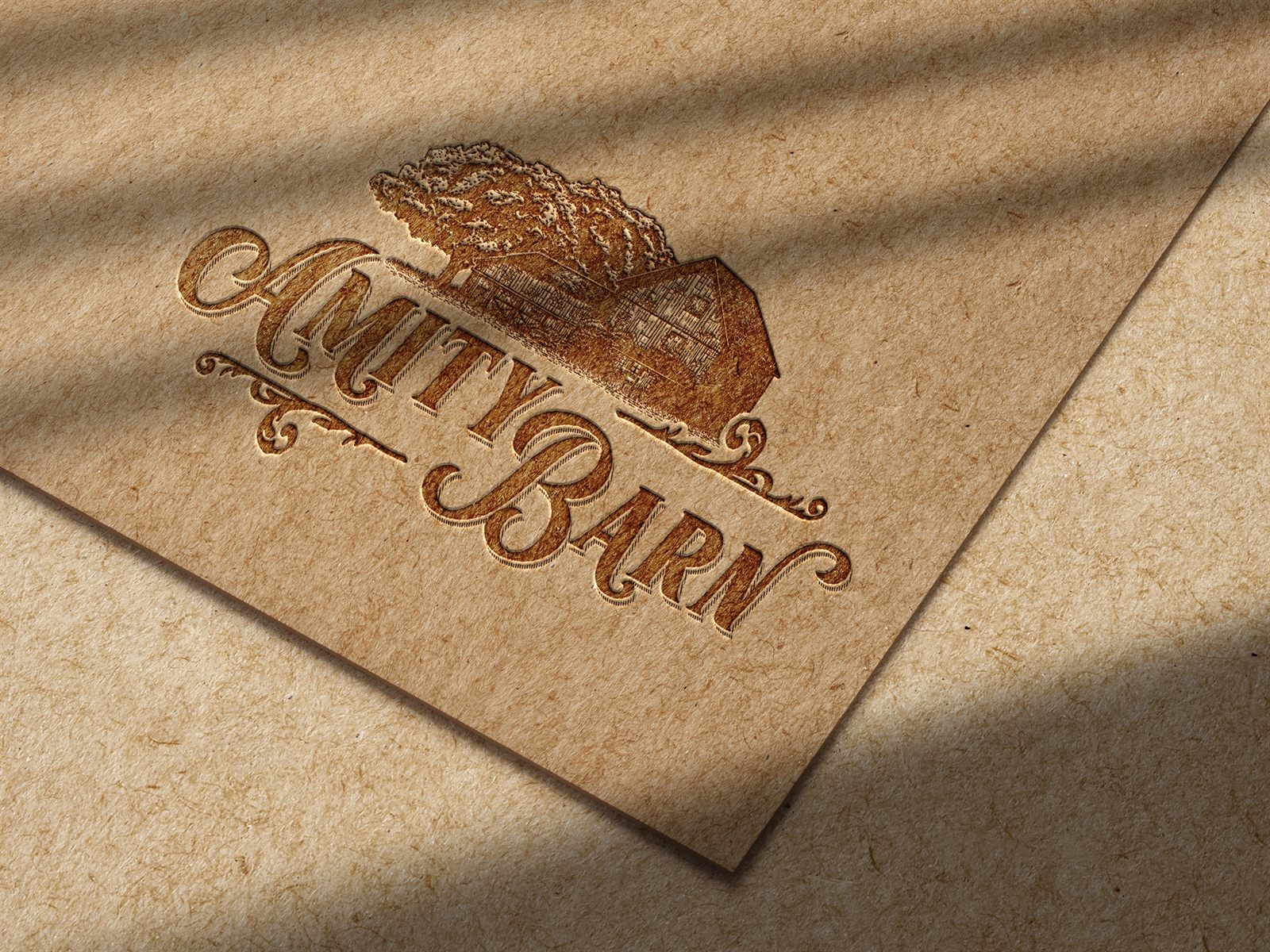 The Amity Barn mark pressed into kraft paper, letterpress style