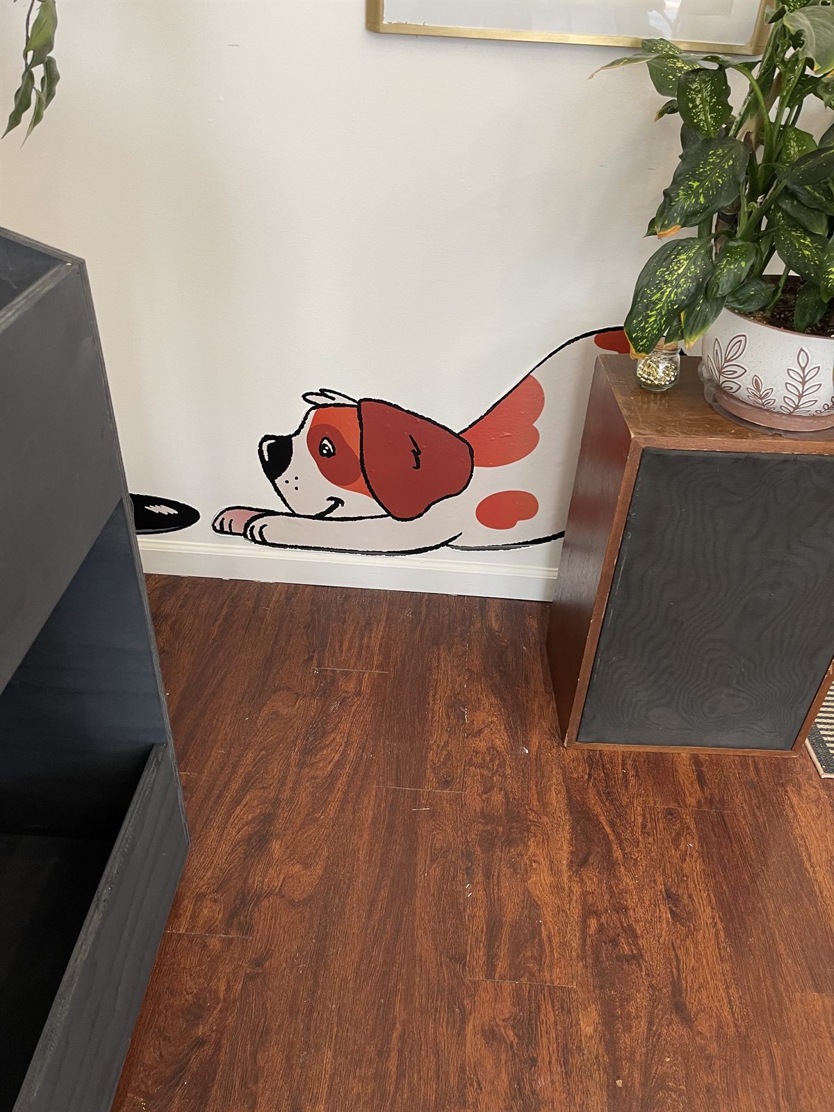 A second mascot graphic near the baseboard, the St. Bernard pawing at a record between the shop's crates and speakers